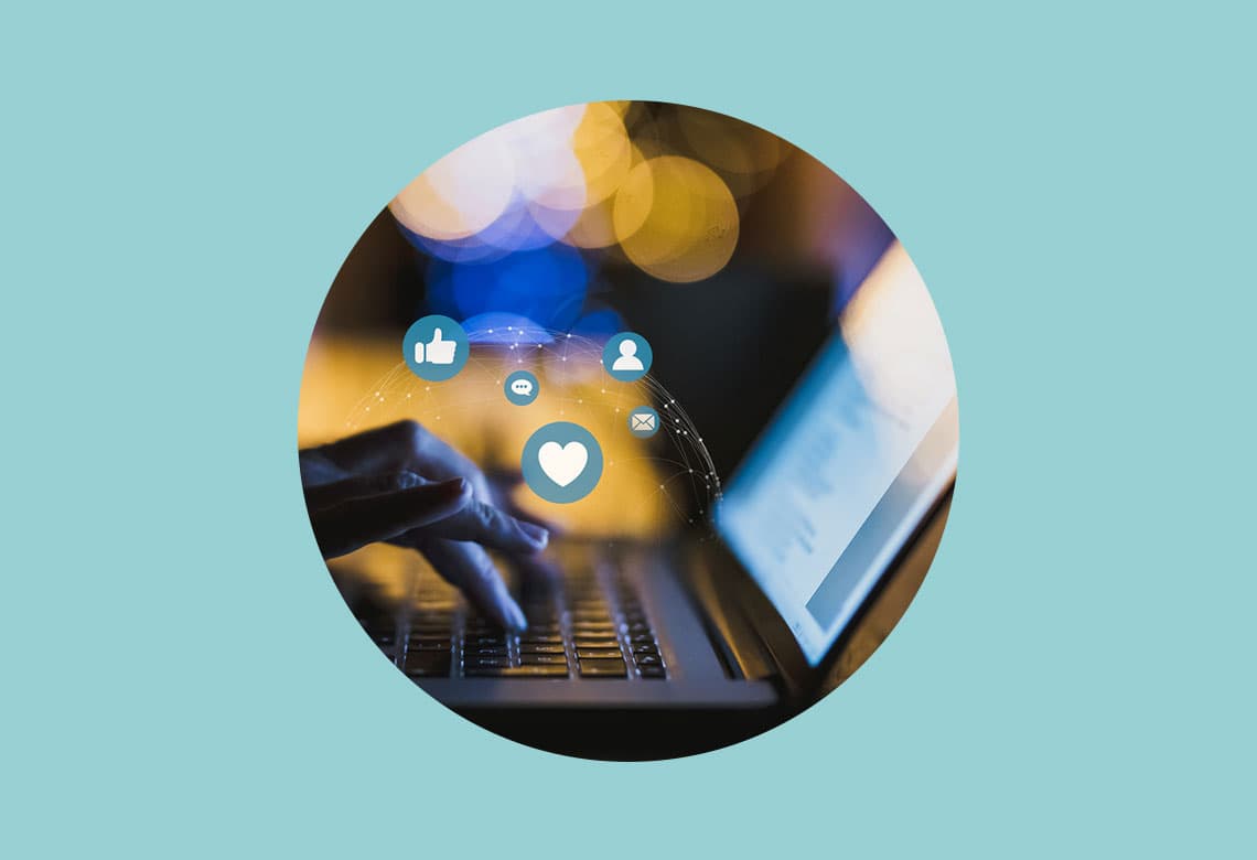 Woman typing on laptop with icon social media stock photo